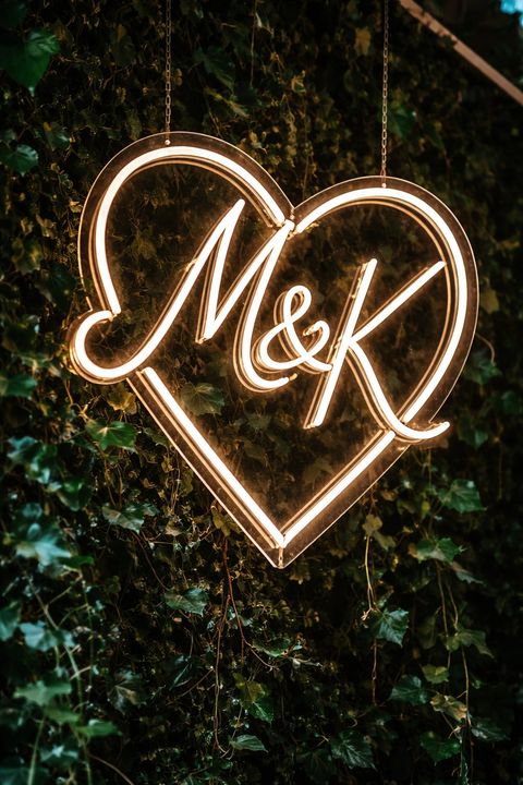Néon cœur M&K sur un mur de lierre